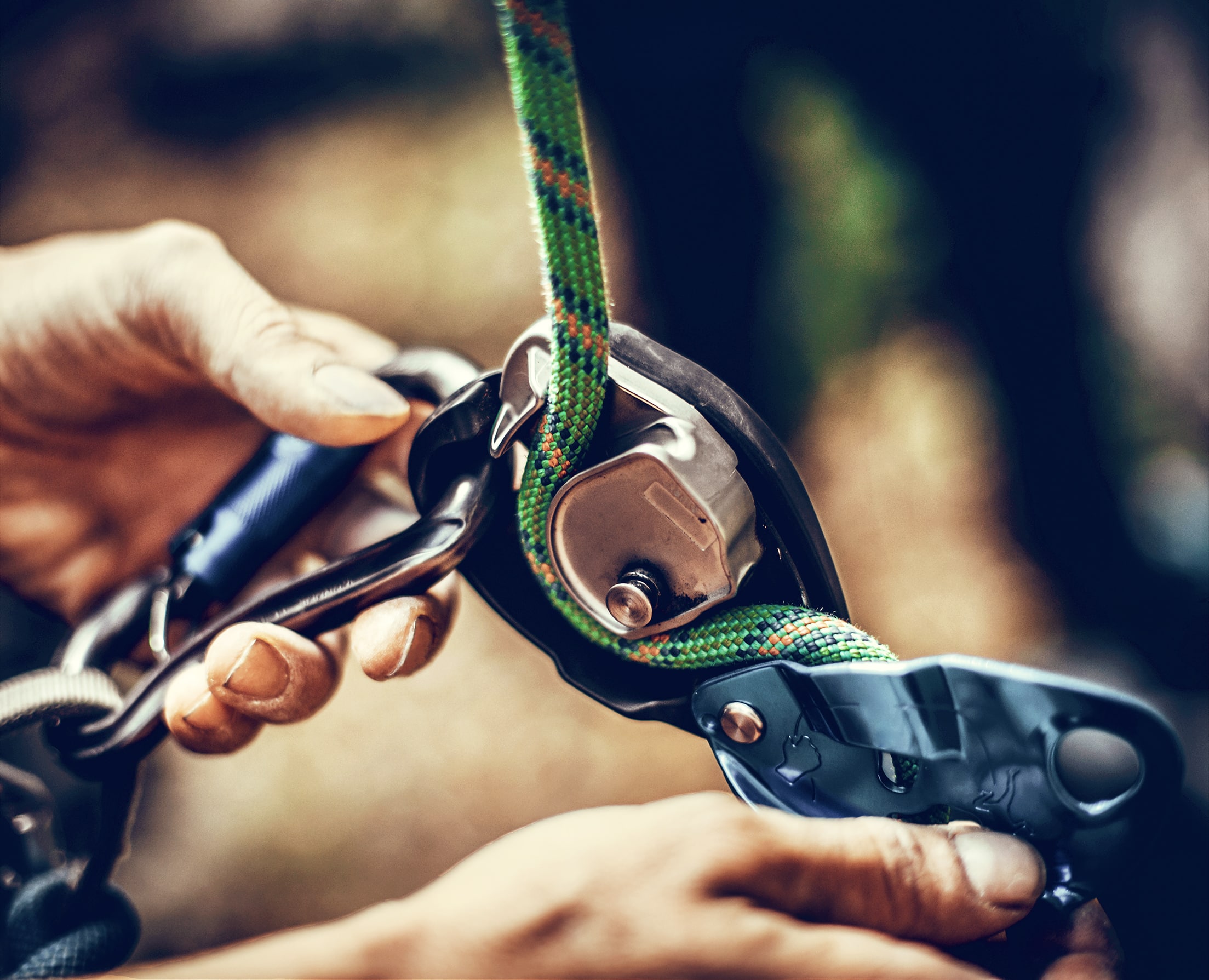 Das Bild zeigt einen Ausschnitt beim Klettern, wo ein Seil mit einem Karabiner gesichert wird. Genauso sicher wie beim Klettern ist auch die Haltung der M&A-Spezialisten von INTAGUS.